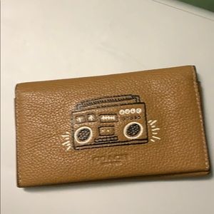 Coach wallet with a music speaker on it.